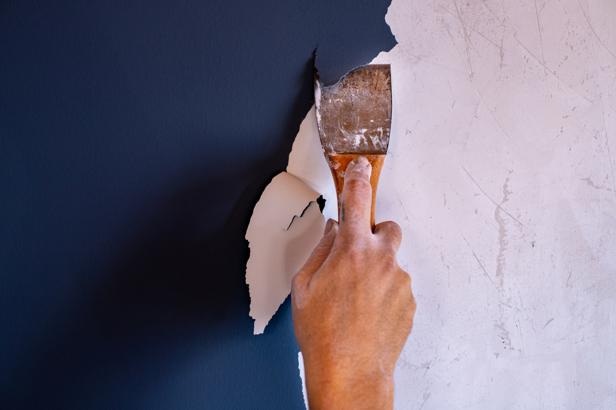 Hand with a spatula renovating the paint.
