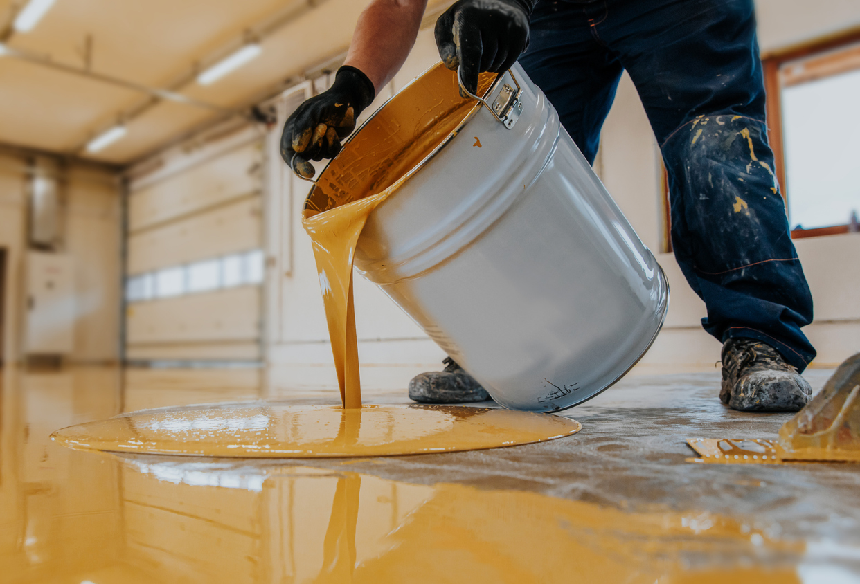 Worker applying a yellow epoxy resin bucket in a Sunol, CA business